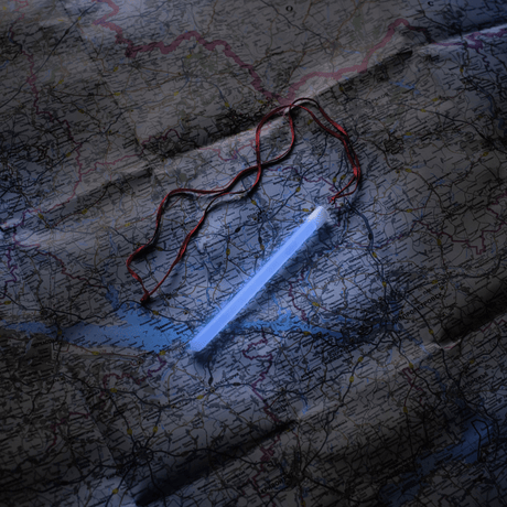 M-Tac Glow Stick 15 cm på kort, ideell for å lyse opp mørke områder og sikre lang holdbarhet i nødsituasjoner.