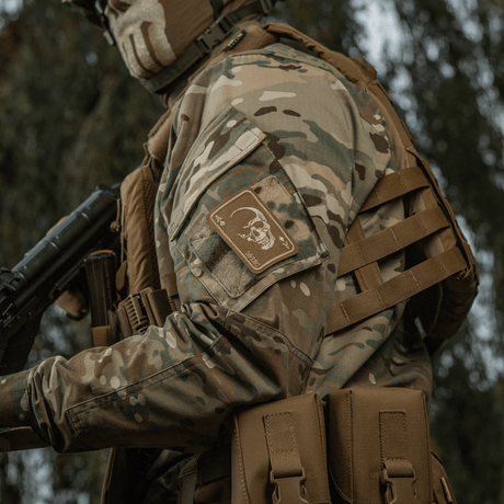 M-Tac Patch Face of War (broderi) på en kamuflasjejakke med et fryktløst kraniemotiv inspirert av Vietnamkrigens dødskort.