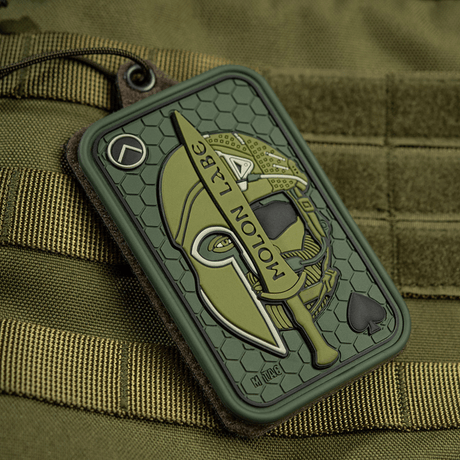 M-Tac Patch Molon Labe 3D PVC med spartansk hjelm og sverd, montert på taktisk bag med Velcro-feste.