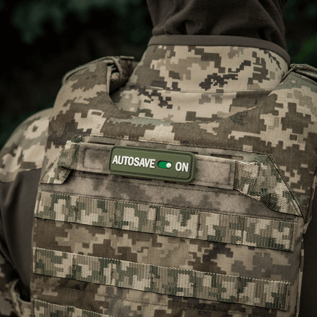 M-Tac Patch Autosave PVC på militærvest med camouflagemønster, 3D moralepatch med Velcro-bakside for enkel festing.