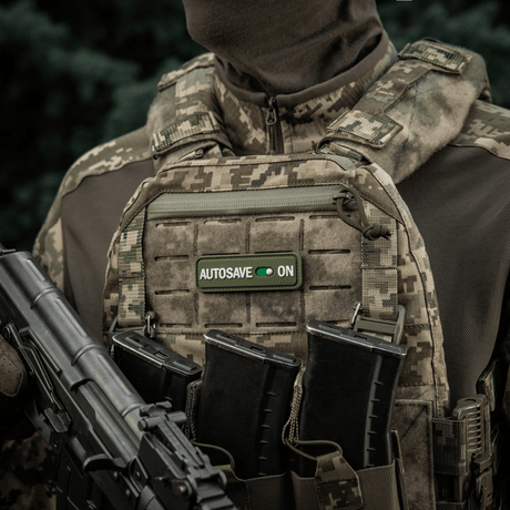 Soldat iført militærvest med M-Tac Patch Autosave PVC med 3D-effekt, Velcro og fullfarge for taktisk bruk.