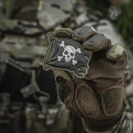M-Tac Patch Jolly Roger PVC i 3D-design, holdt av hanskekledd hånd, symboliserer eventyrlyst, med Velcro på baksiden, 8x5 cm.