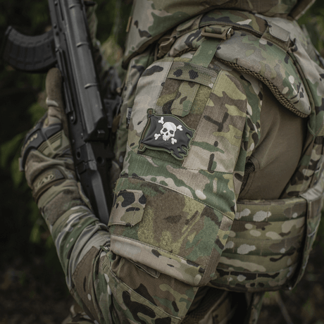 Soldat i uniform med M-Tac Patch Jolly Roger PVC på armen, fullfarget 3D morale patch med Velcro, symboliserer eventyrlyst og besluttsomhet.