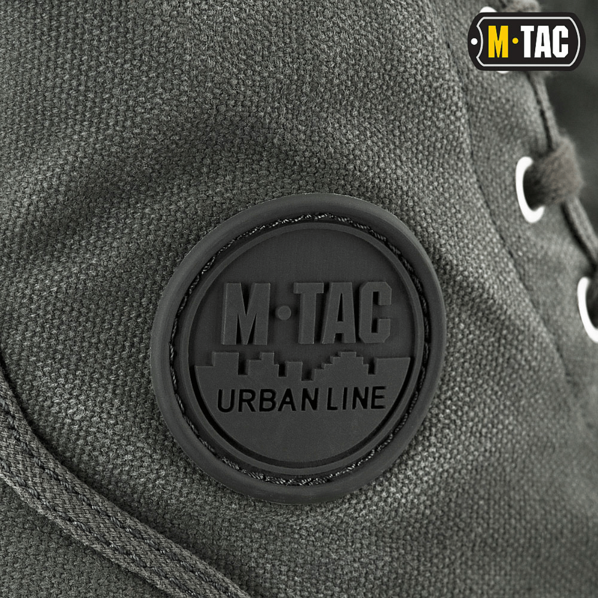Nærbillede af M-Tac Sneakers med klassisk design og holdbart bagoverlay for udendørs brug, fokus på metalliserede snørehuller.