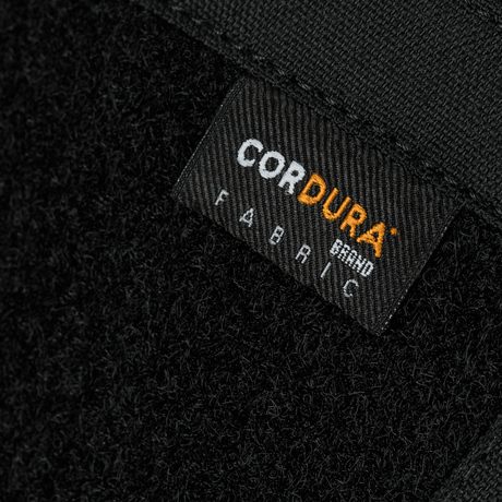 Nærbilde av Cordura-stoffmerke på M-Tac Sphaera Hardsling Bag Large Elite med Velcro, laget av holdbare materialer.