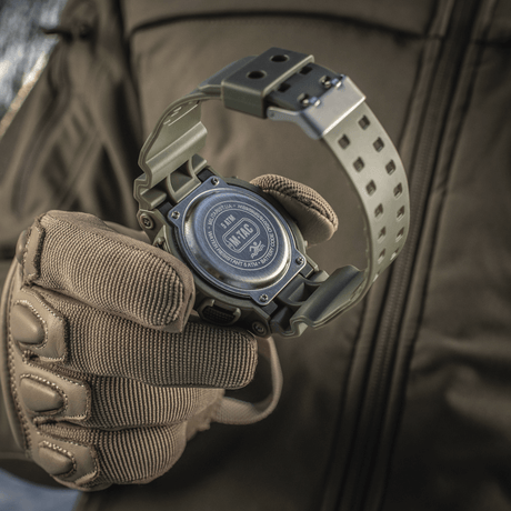 M-Tac Sport-klokke med robust design og vannavvisende funksjon, perfekt for friluftsaktiviteter og sport, vist på en taktisk hanske.