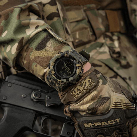 M-Tac Tactical Ur 2037 på hånd iført camo, viser robust design med LED-bakgrunnsbelysning og funksjoner for taktisk bruk.