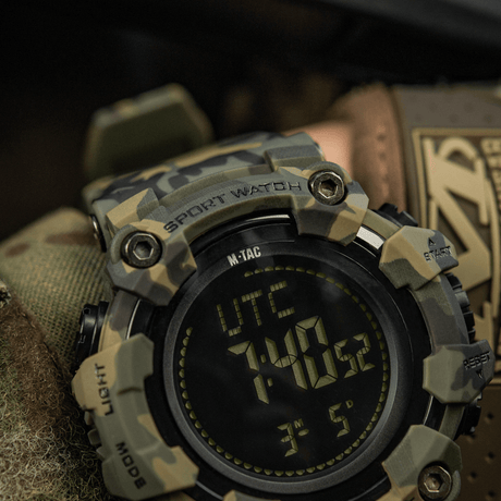 M-Tac Tactical Ur 2037 i robust camouflagedesign med LED-bakgrunnsbelysning og funksjoner som kompass og stoppeklokke. Ideell for utendørs og taktisk bruk.
