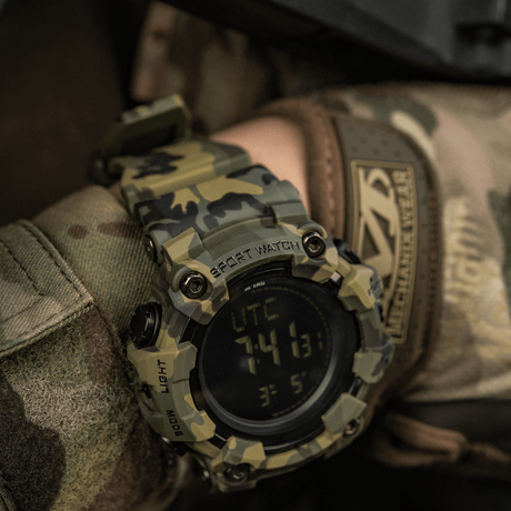 M-Tac Tactical Ur 2037 i camouflagedesign; ideell for utendørs og taktisk bruk, med funksjoner som kompass og LED-lys.