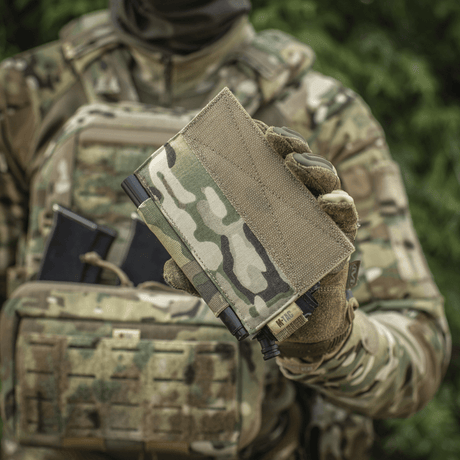 M‑Tac Tourniquet Pouch Elastic Gen.5 holdt av soldat i kamuflasjeuniform, ideell for CAT tourniquet på taktisk utstyr.