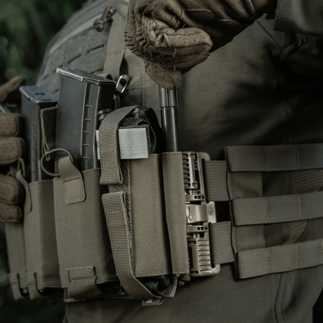 M‑Tac Tourniquet Pouch Elastic Gen.5 festet på taktisk utstyr med elastikkbånd og velcro, ideell for oppbevaring av CAT tourniquet.