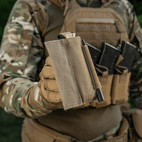 M‑Tac Tourniquet Pouch Elastic Gen.5 holdt av soldat i taktisk utstyr, viser Cordura-materiale og praktisk design for CAT tourniquet.