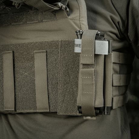 M‑Tac Tourniquet Pouch Elastic Gen.5 festet på taktisk utstyr, viser sikker fastgjøring med elastisk bånd og velcro.