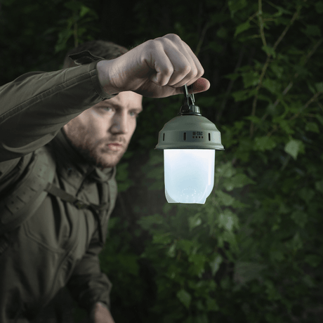 Mann holder M-Tac Turist Hengelampe i skogen, ideell for camping, fiske og jakt med 200 lumen LED-lys.