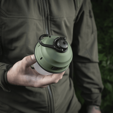 M-Tac Turist Hengelampe i bruk, holdt i hånd, ideell for camping og utendørsaktiviteter, med retrodesign og moderne LED-teknologi.