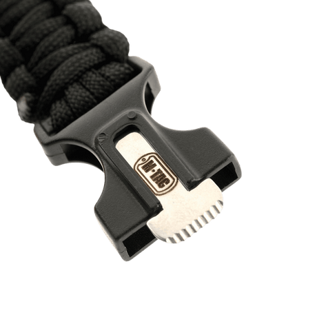 M-Tac Paracord armbånd med ildstarter, kompass og fløyte i nærbilde av svart bukkellås.