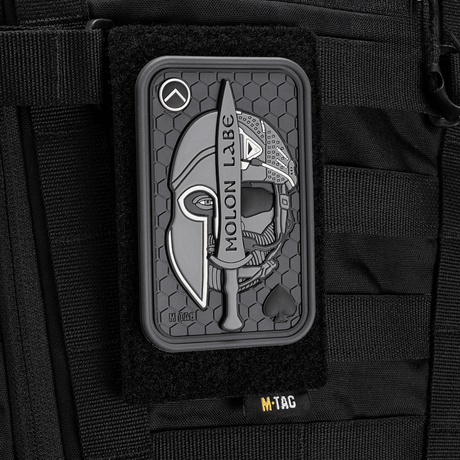 M-Tac Patch Molon Labe 3D PVC med spartansk design og Velcro, festet på taktisk sekk. Gummimateriale med 3D-effekt. Dimensjoner: 108x68 mm.