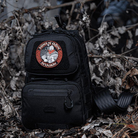 Svart ryggsekk med M-Tac Patch Sons of Odin 3D Velcro i skogkledd område, egnet for taktisk bruk og fritid