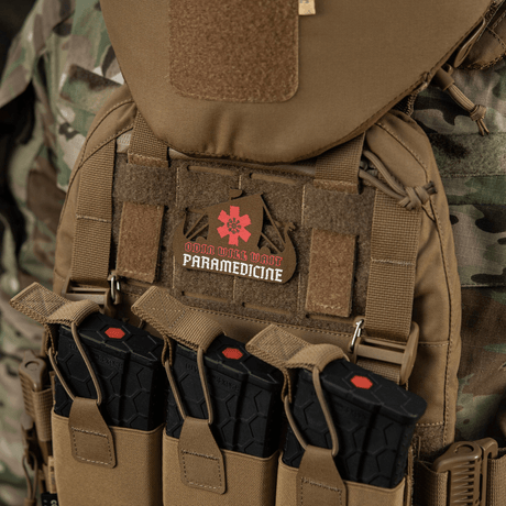 M-Tac Patch Viking Evac på taktisk vest, kamuflasjebakgrunn, inneholder paramedicinsk emblem.