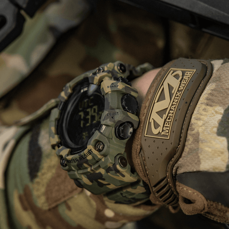 M-Tac Tactical Ur 2037 med camouflagedesign båret av en person iført taktisk utstyr.