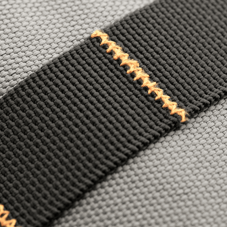 Nærbilde av M-Tac Urban Line City Patrol veske: svart skulderrem med oransje søm, 600D polyester, vannavvisende egenskaper.