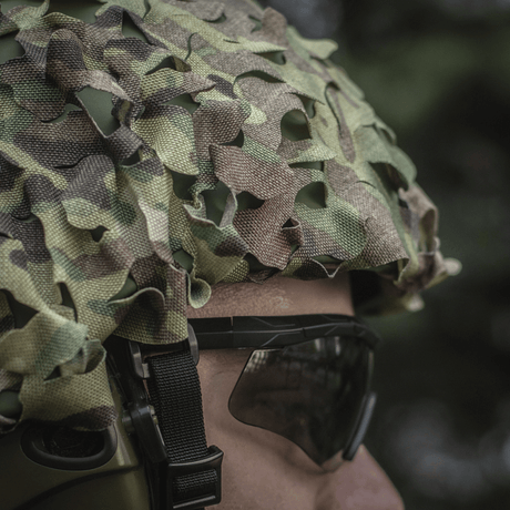 M‑Tac Vilha Hjelmcover Elite i Multicam-camouflage på en person, klar til å beskytte hjelmen mot smuss og slitasje under krevende forhold.