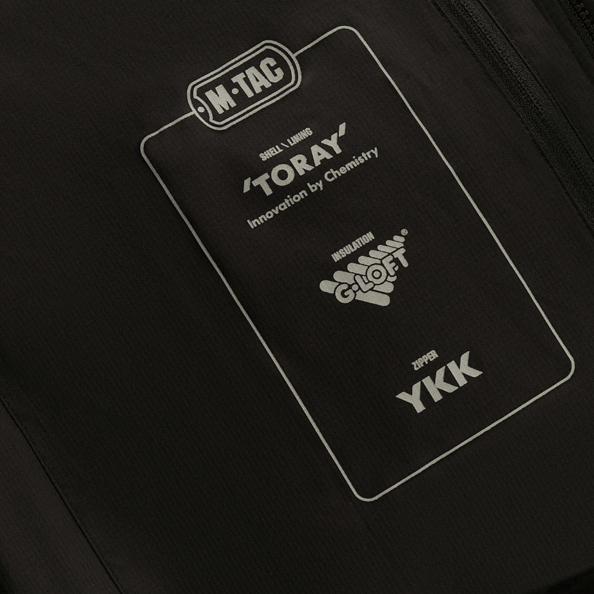 Detaljeret billede af M-Tac Paladin Jakke med Toray-materiale og YKK-lynlås, ideel til temperaturer fra 0 til -15°C.