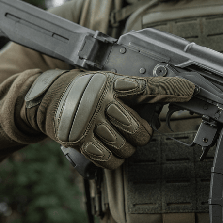 M-Tac Handsker Assault Tactical Mk.2 greb om et våben, med støddæmpende inserts og velcro-lukning for maksimal beskyttelse og komfort.