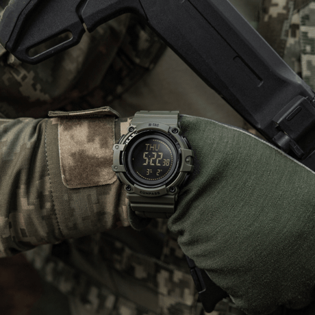 M-Tac Tactical Ur med Kompass 2233 båret av taktisk utstyr brukt av en person, ideelt for utendørs og taktisk bruk, med LED-bakgrunnsbelysning.