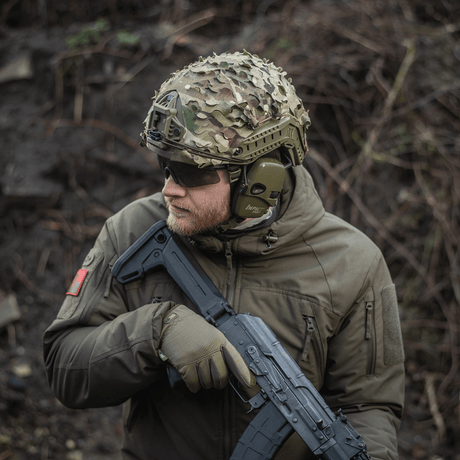 M‑Tac Vilha Hjelmcover FAST på en hjelm med kamuflasje i ujevnt terreng, laget av Cordura 500D for holdbarhet.