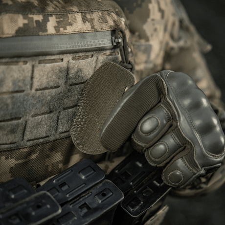 Soldat iført taktisk utstyr og hansker fester M-Tac Patch M67 Granat 3D PVC med Velcro-bakside på kamuflasjeuniform.
