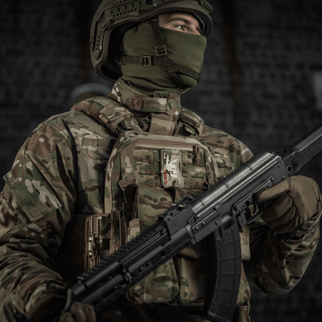 Soldat i kamuflasje med M-Tac Patch Bad Boy (broderi) på vesten, utstyrt med stormgevær, symboliserer styrke og mot.
