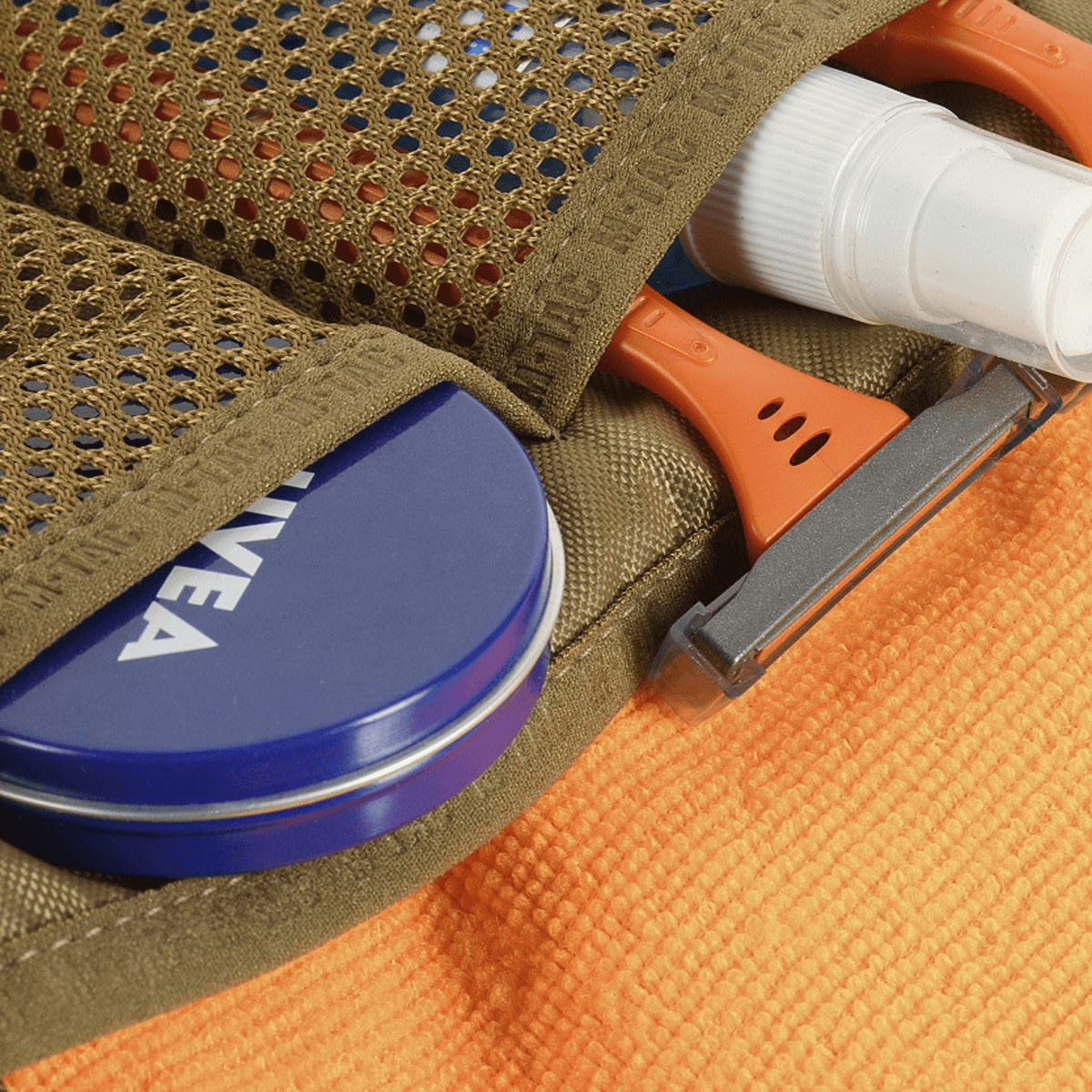 M-Tac Toilettaske Elite Gen.II med barberartikler, tandpasta og lotion opbevaret organiseret i en kompakt rejsetaske.