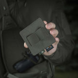 Person holding M-Tac Double Mag Pouch Hook Backed Magazine, showcasing the compact design suitable for various gear.