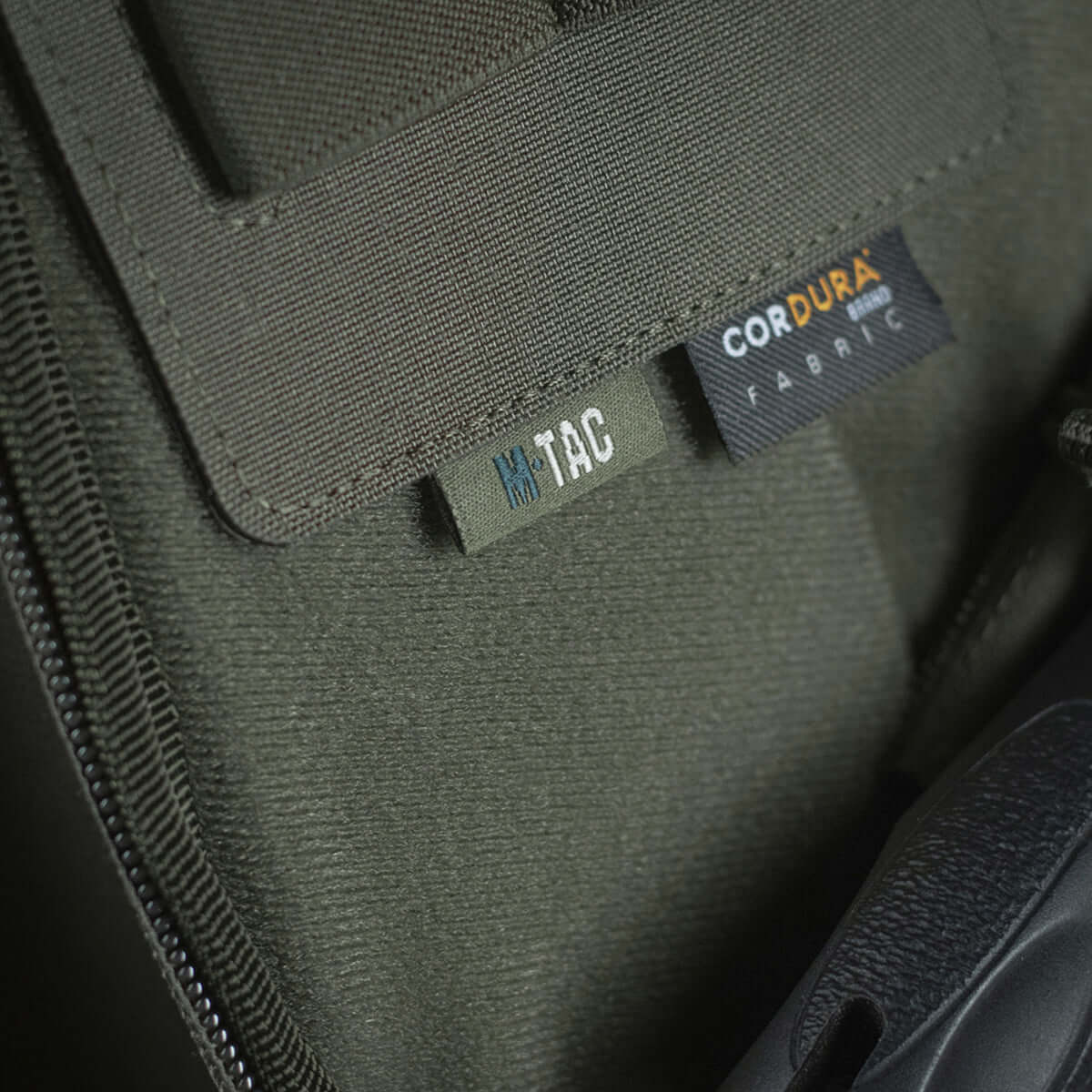Nærbillede af M-Tac Double Mag Pouch Hook Backed Magazine med Velcro-fastgørelse og Cordura label i grønt stof.