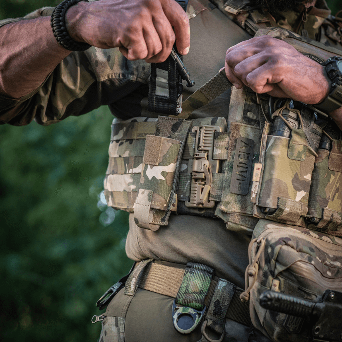 Soldat bærer M-Tac Tourniquet Pouch Elastisk med MOLLE Gen.II på militærudstyr i naturlige omgivelser.