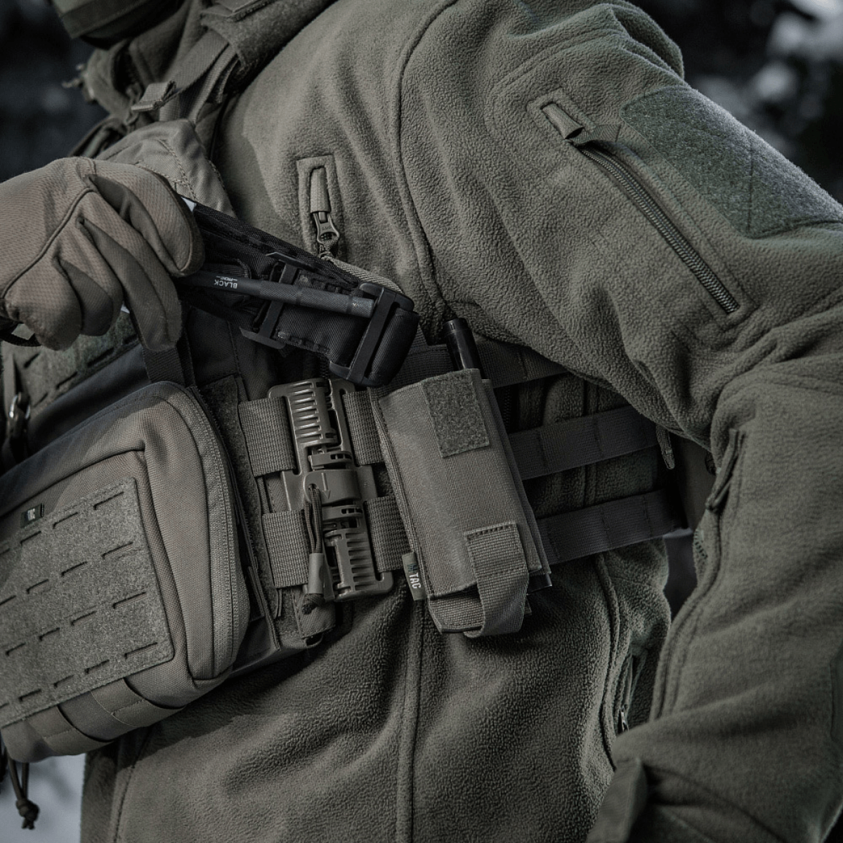 M-Tac Elastisk Tourniquet Pouch Molle Gen.III monteret på taktisk vest, indikerer hurtig adgang og sikker opbevaring af tourniquet.