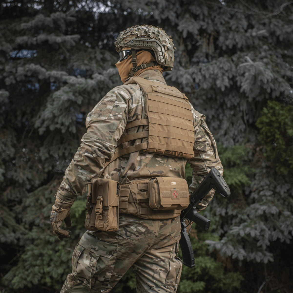 Soldat iført M‑Tac Plate Carrier Cuirass QRS Gen.II i skovmiljø, med quick-release system til taktisk brug. Materiale: Cordura 500D.