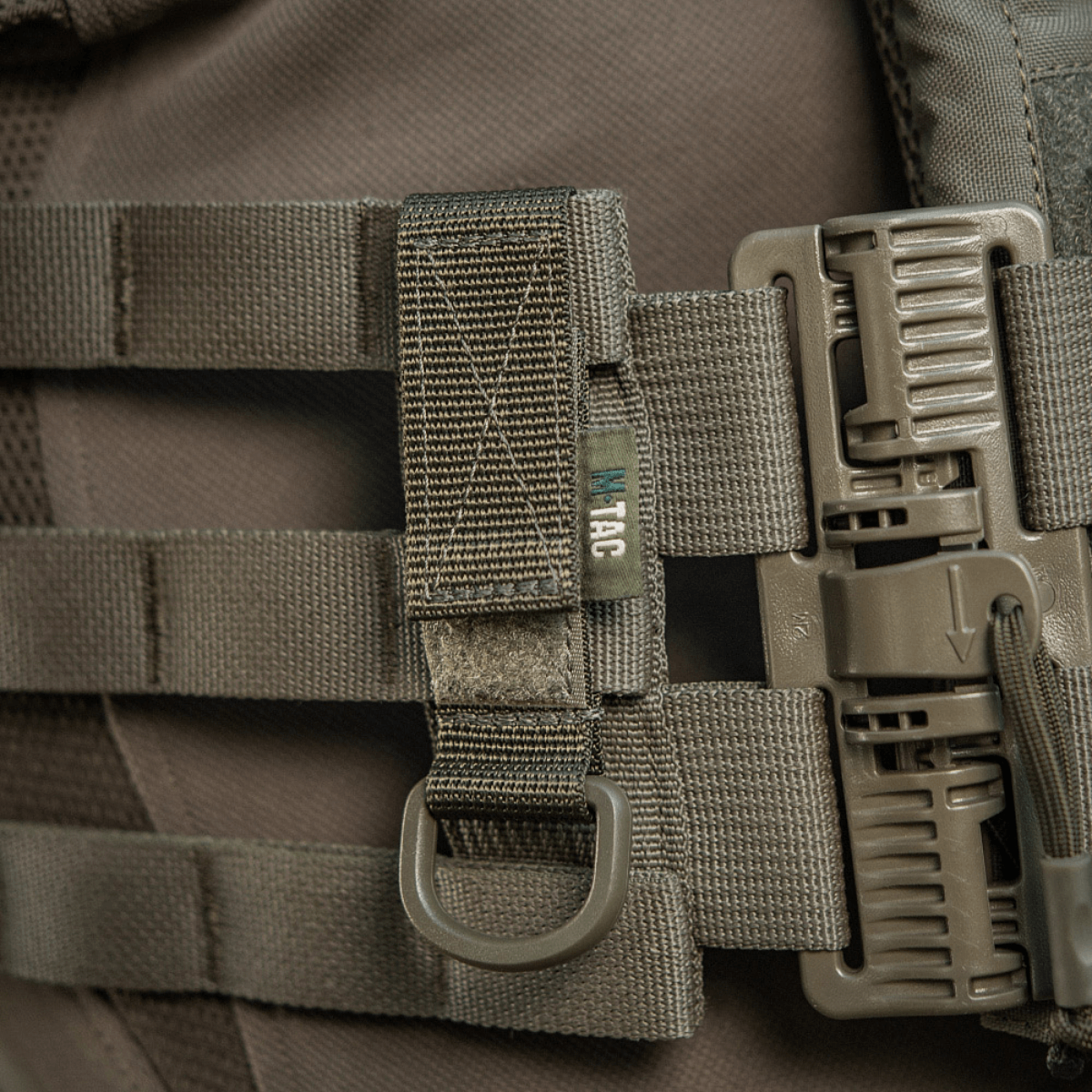 M-Tac Fastgørelse med D-ring monteret på MOLLE-system med velcro-lukning, ideel til taktisk brug og let justerbar.