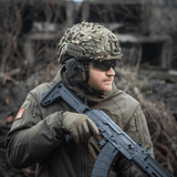M‑Tac Vilha Hjelmdække FAST i Multicam mønster, bæret med camouflagehjelm og beskyttelsesudstyr i ujævnt terræn.