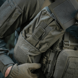 Person wearing a tactical vest with M-Tac Medic Pouch Vertical Large Elite attached, showcasing outdoor gear durability and functionality.
