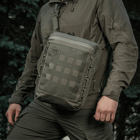Person wearing the M-Tac Tablet Bag Laser Cut Hex with MOLLE panel outdoors