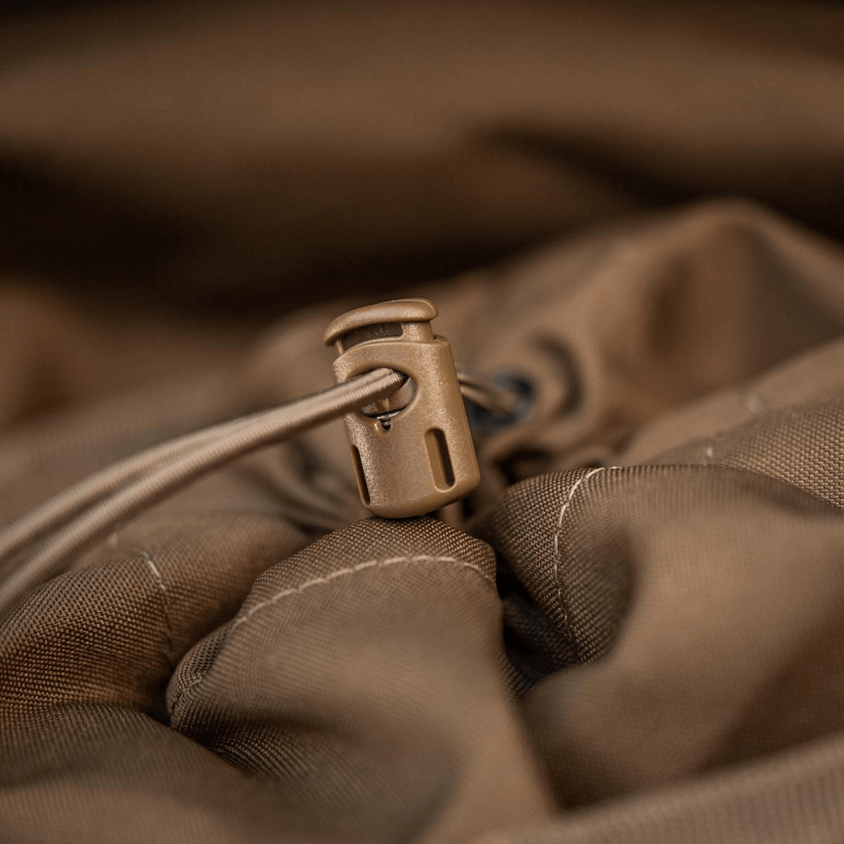 Detalje af snorstoppersystem på M-Tac Sukharka Gen.3 Pouch lavet af holdbart Cordura 500D materiale.