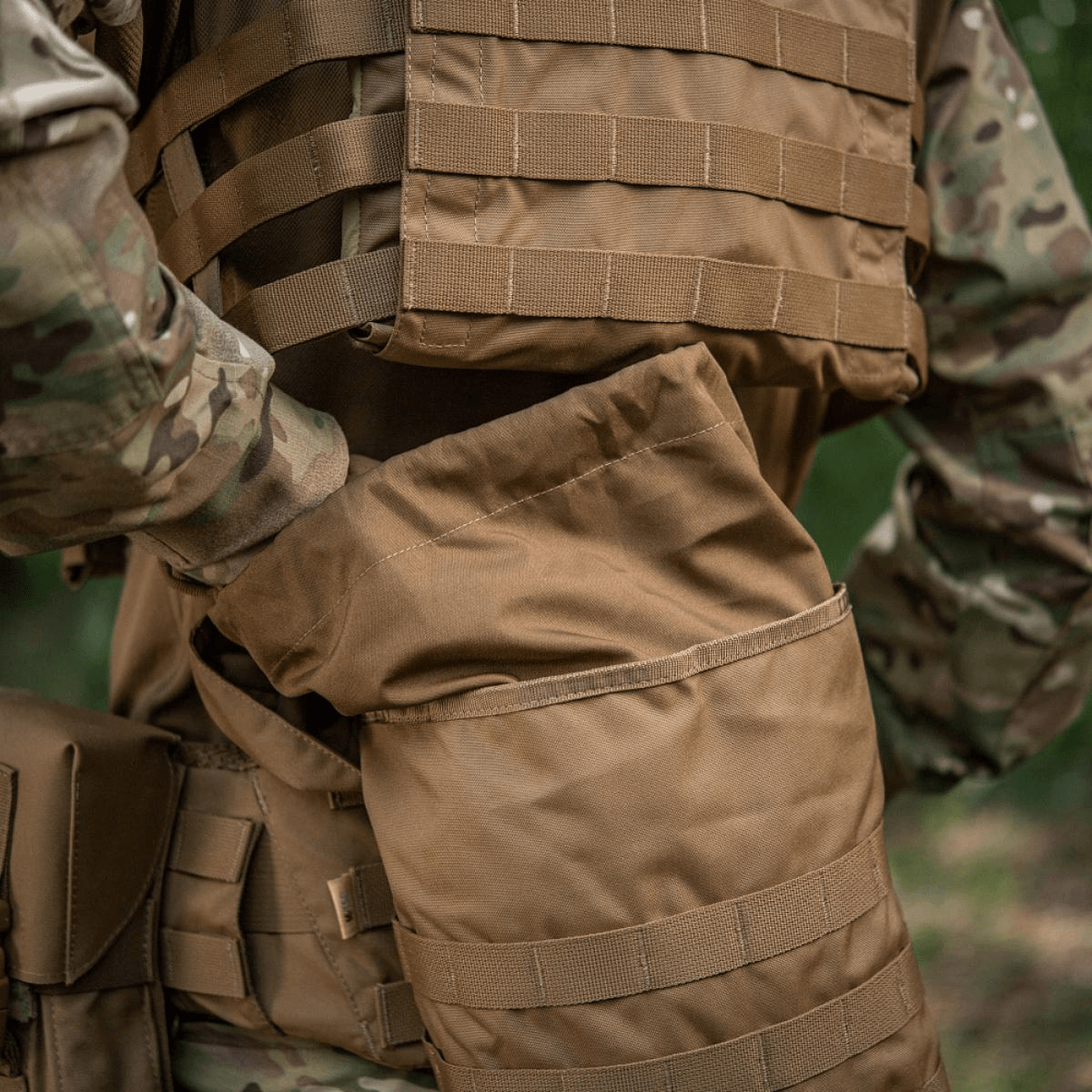 M-Tac Sukharka Gen.3 Pouch, robust feltpose i Cordura 500D med MOLLE-interface, bæres af en person i militæruniform.