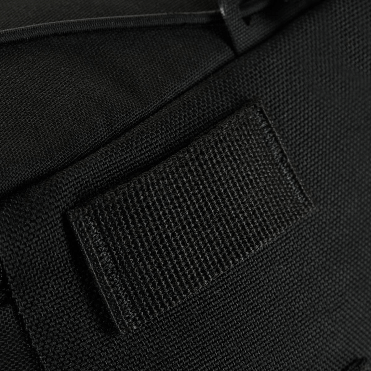 Nærbillede af et sort stofmateriale med en velcro strop.