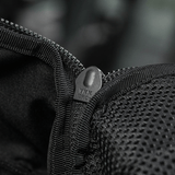 Nærbillede af sort lynlås på rygsæk med netdetaljer, der viser YKK-mærket, fokus på holdbarhed og kvalitet.