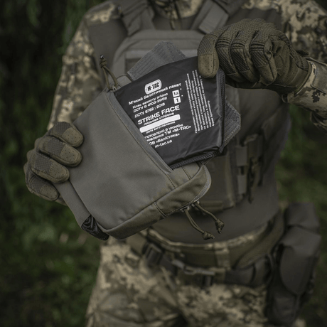 Person holder M-Tac Large Elite Gen.II Skuldertaske med Cordura 500D materiale og YKK lynlåse til taktisk brug og daglig transport.