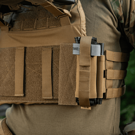 M‑Tac Tourniquet Pouch Elastic Gen.5 fastgjort til taktisk udstyr, vist i brug med velcro fastgøring på plate carrier.