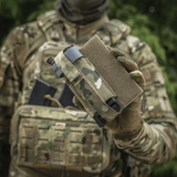M‑Tac Tourniquet Pouch Elastic Gen.5 fastgjort til taktisk udstyr i camouflagedesign, hurtig adgang til CAT tourniquet med elastikbånd og velcro.