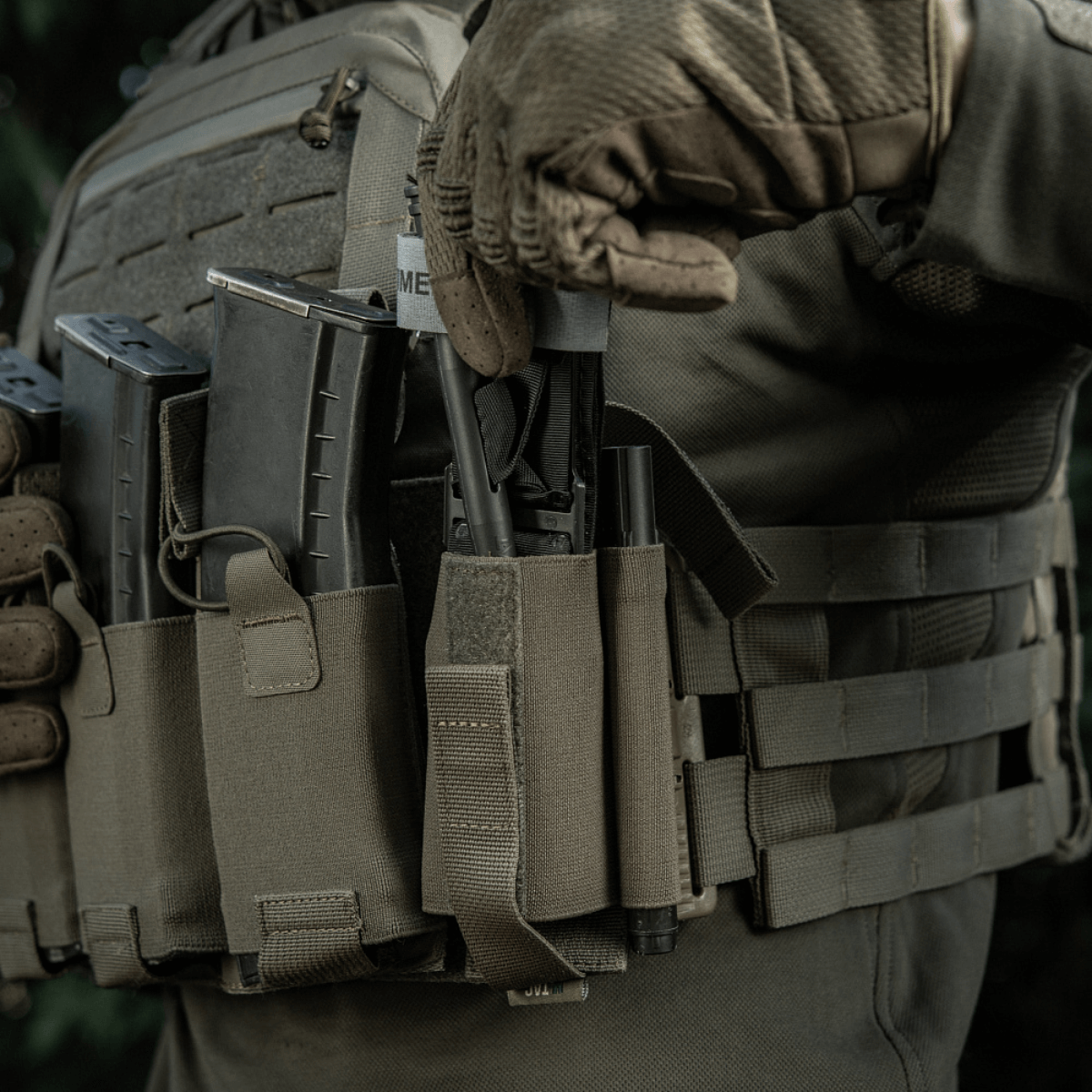 Taktisk udstyr med M‑Tac Tourniquet Pouch Elastic Gen.5 fastgjort til bærer for let adgang og sikker opbevaring af en tourniquet.